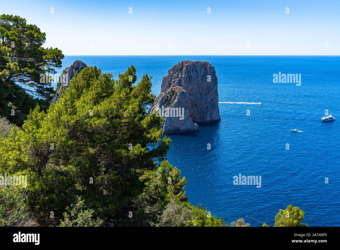 View of Faraglioni, three majestic rocks that emerge from the sea, the ...