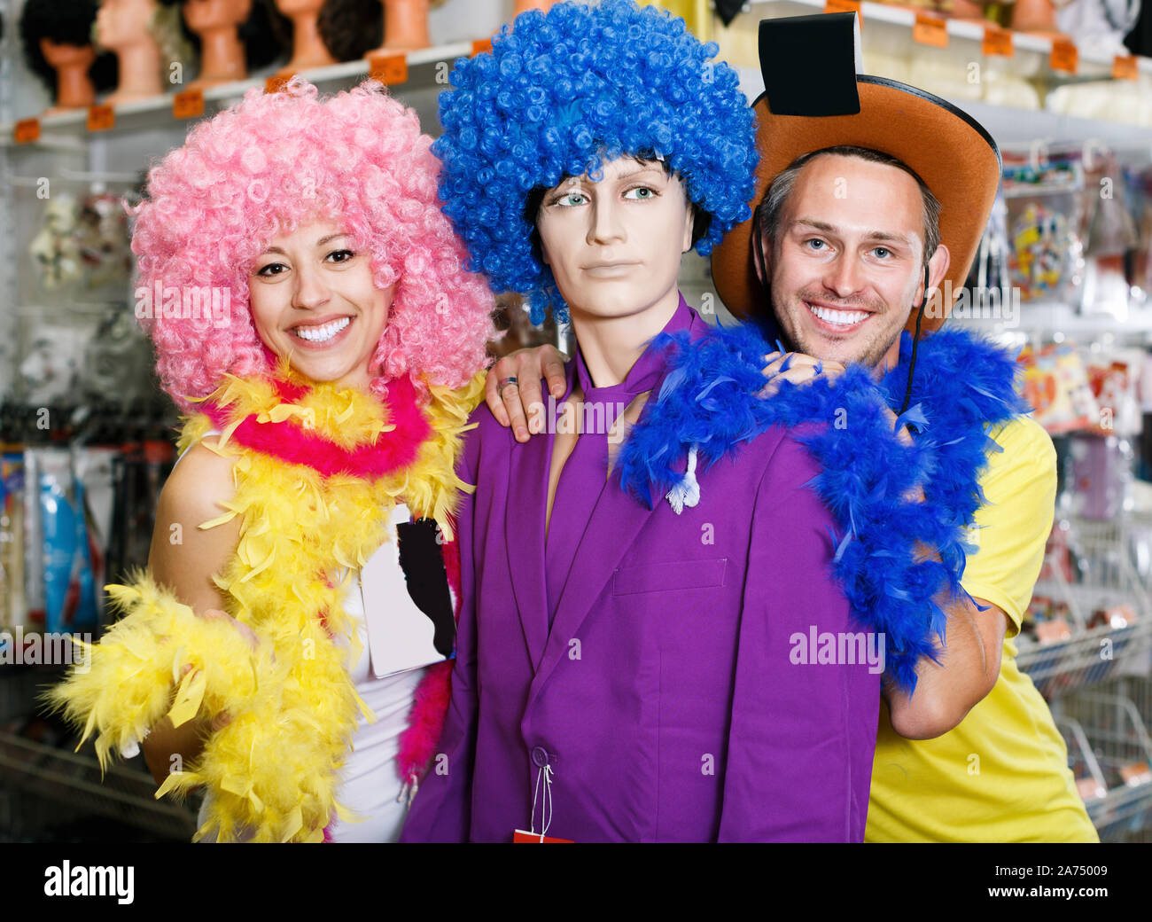 Portrait of laughing girl and guy with mannequin at shop Stock Photo