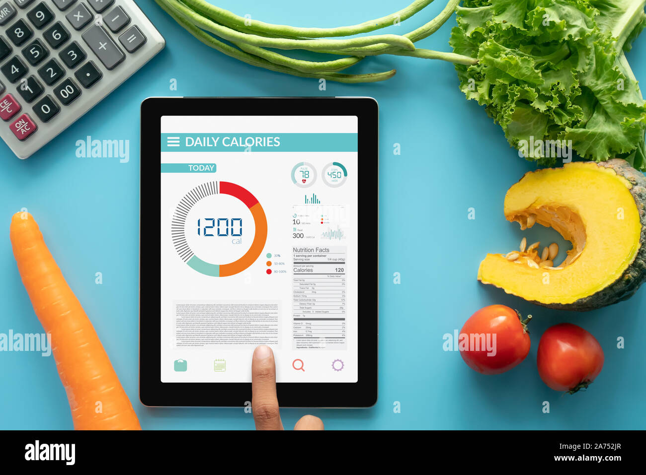 Calories counting , diet , food control and weight loss concept. woman using Calorie counter application on tablet at dining table with fresh vegetabl Stock Photo