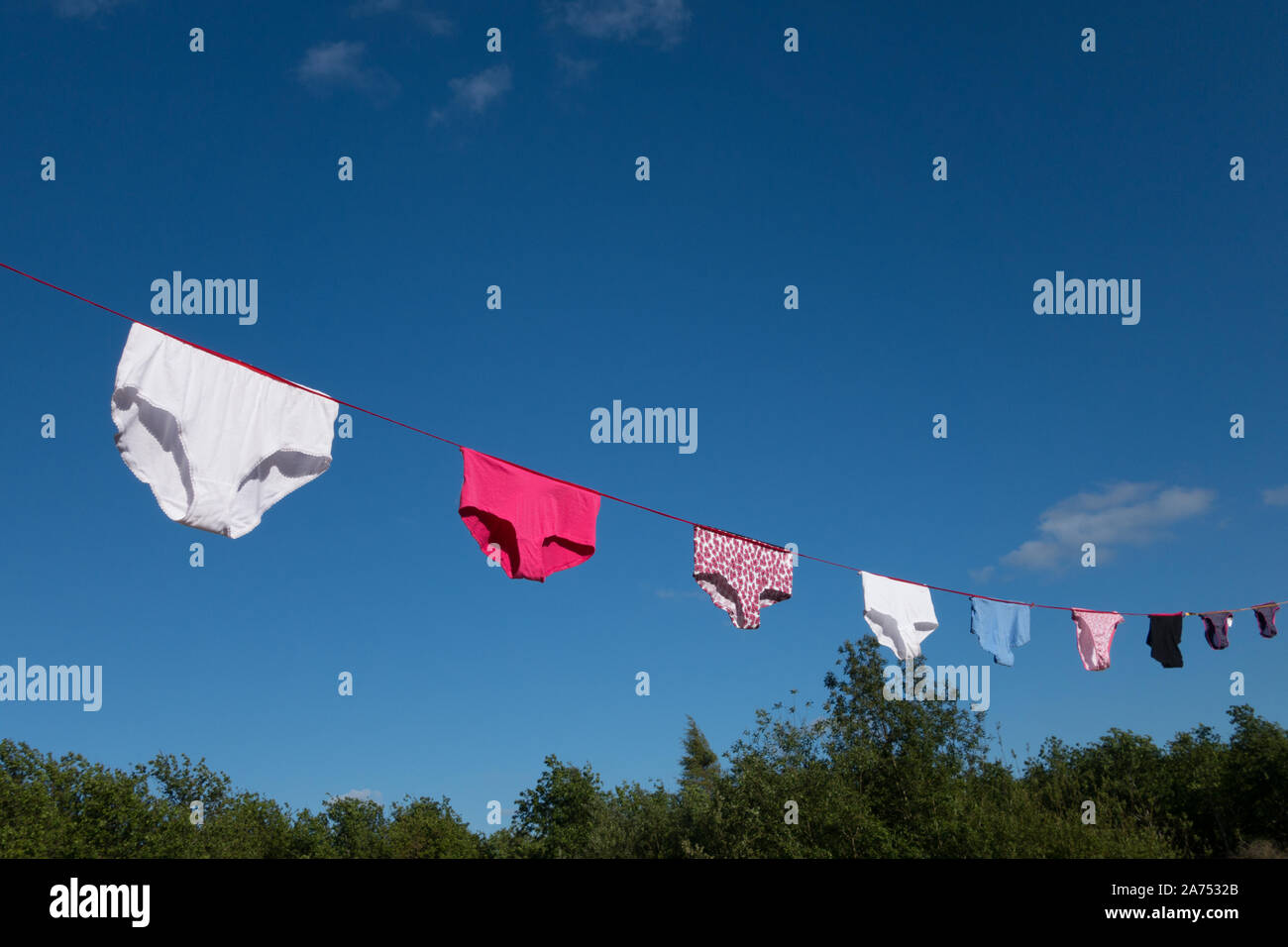 Underwear and Knickers hanging out to dry on a washing line against a blue sky Stock Photo