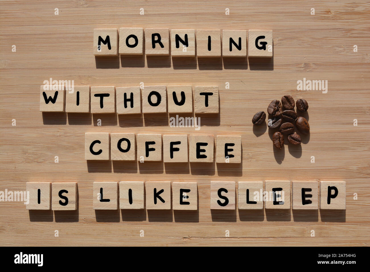 Morning Without Coffee is Like Sleep. Words in 3d wooden alphabet letters with coffee beans  on a bamboo wood background Stock Photo