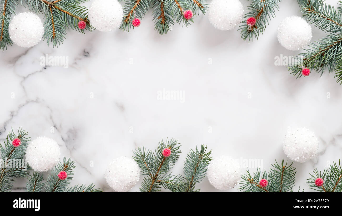christmas frame made of fir branches and balls on marble background ...