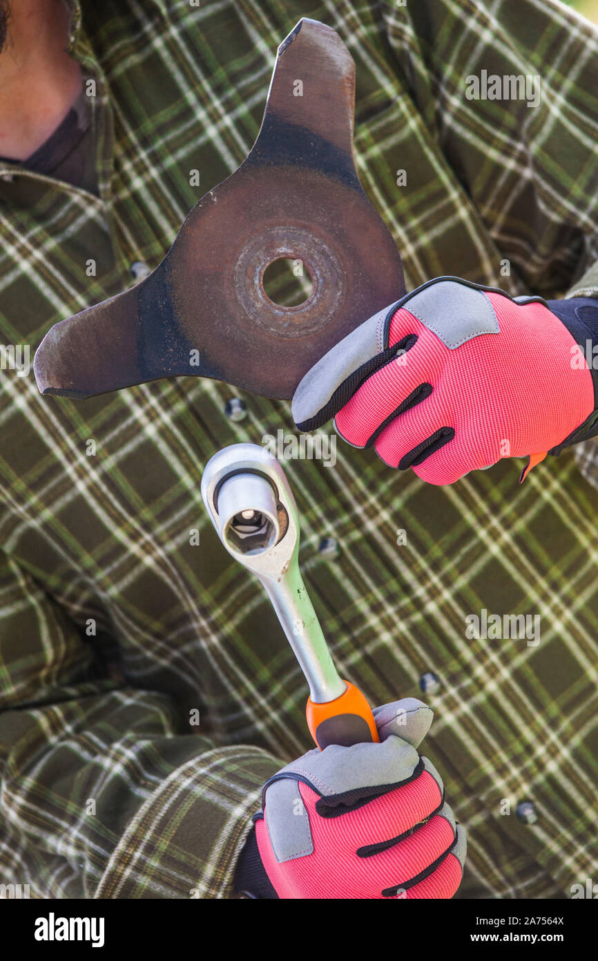 Preparation of equipment for winter: brushcutter blade removed for sharpening. Stock Photo