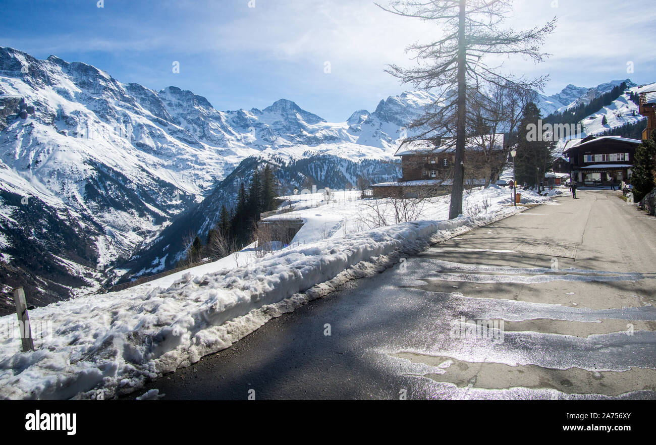 Walking between Murren village In Switzerland to the cable car station in a very beautiful path through an amazing snowy mountains landscape. Stock Photo