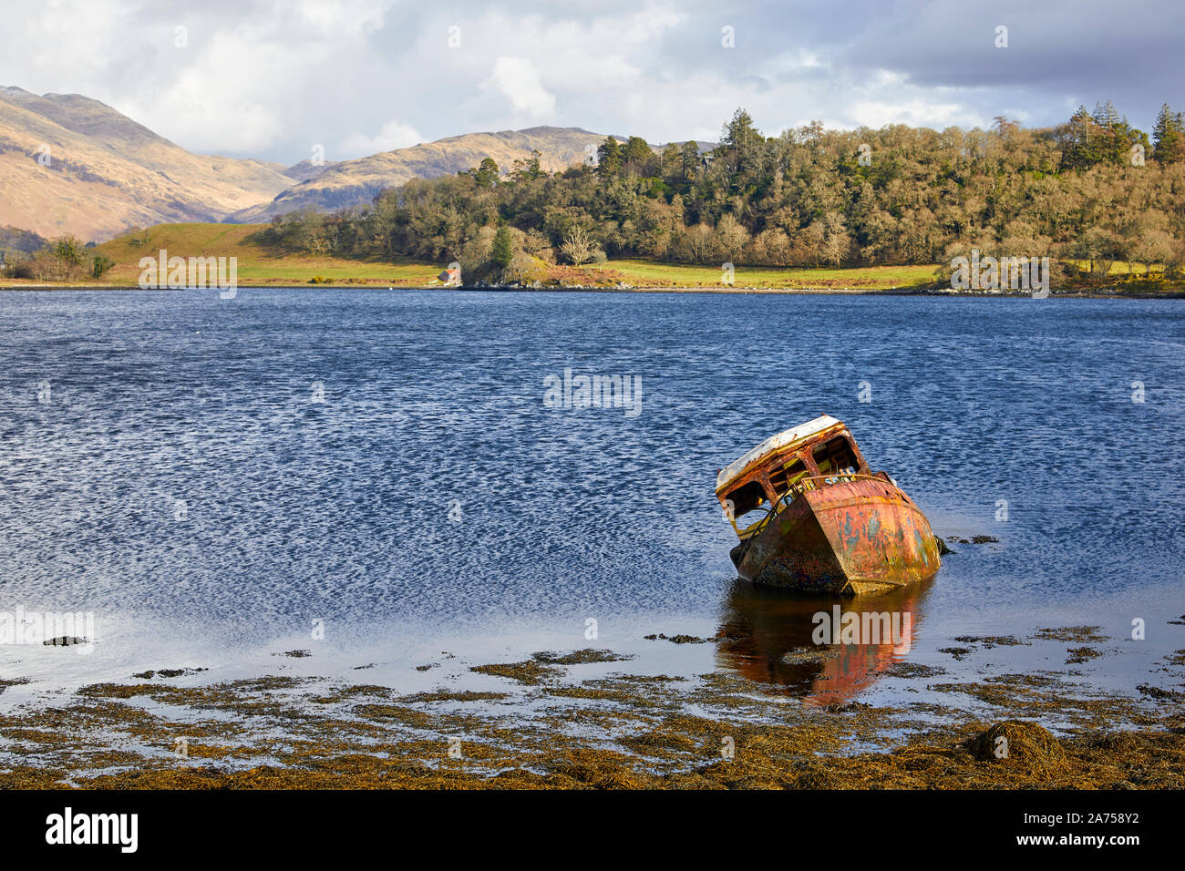 Half sunken wreck of fishing boat on Loch Etive Stock Photo
