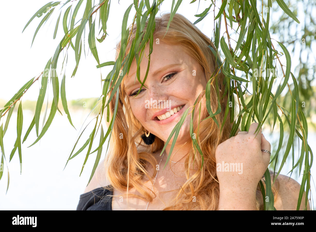 Portrait of a gorgeous smiling teenage girl with red hair outdoors Stock Photo