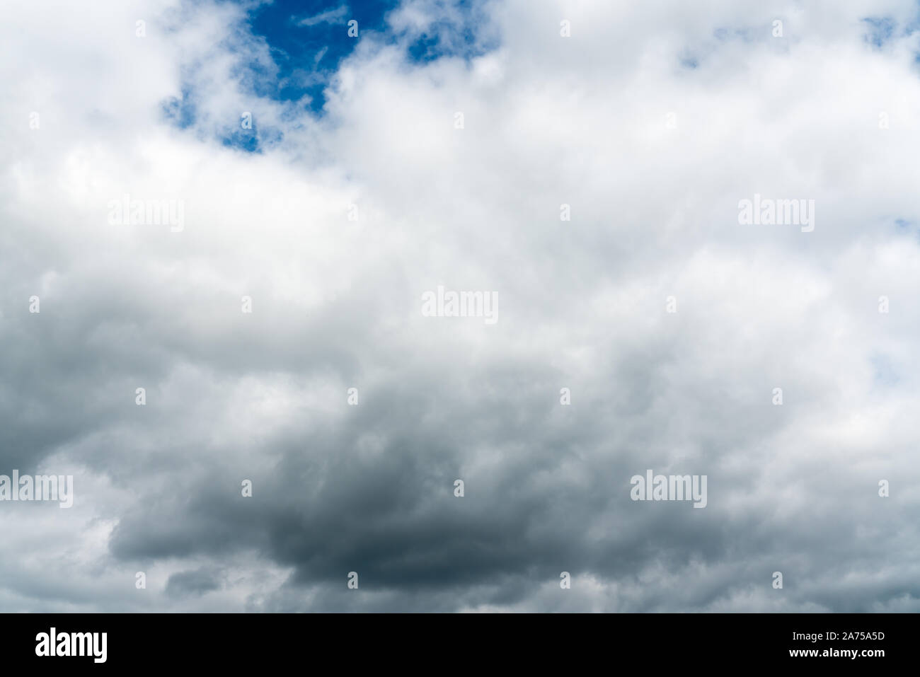 stormy cloudy sky with patches of blue and white clouds horizontal background Stock Photo