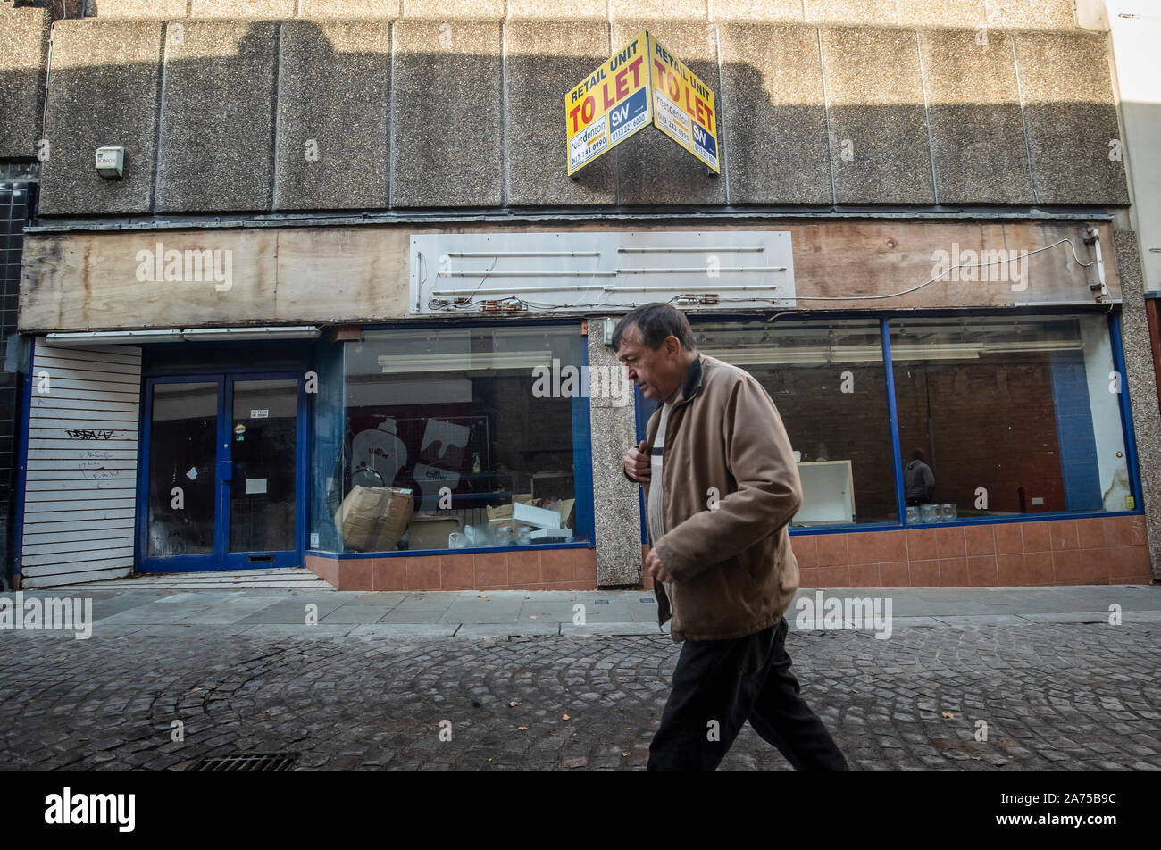 A man walks past a closed shop in Halifax in Yorkshire, as a think tank says the Conservatives will have to target traditional Labour voters from regional towns in order to win the general election. Stock Photo