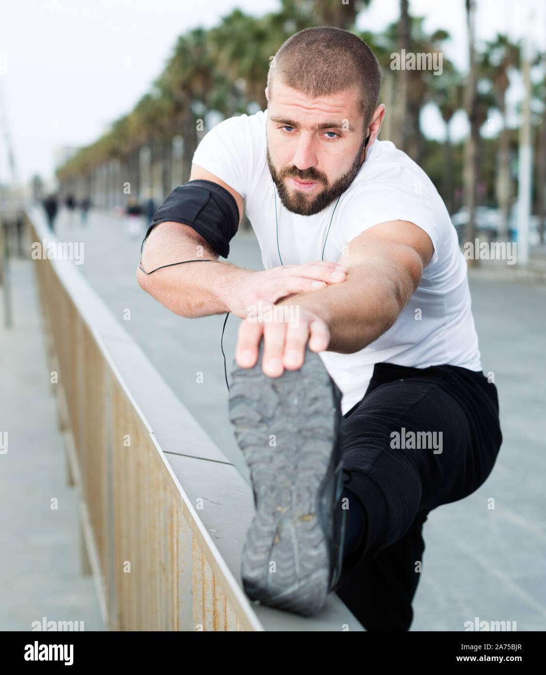 Athletic male performs warmup exercises before training Stock Photo