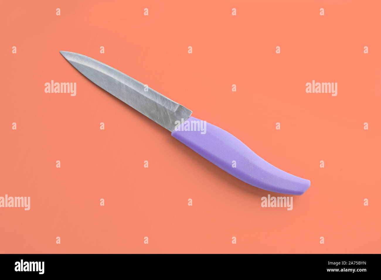 Kitchen utensils - a small knife for vegetables with a plastic handle on a  coral background. Cooking tools Stock Photo - Alamy