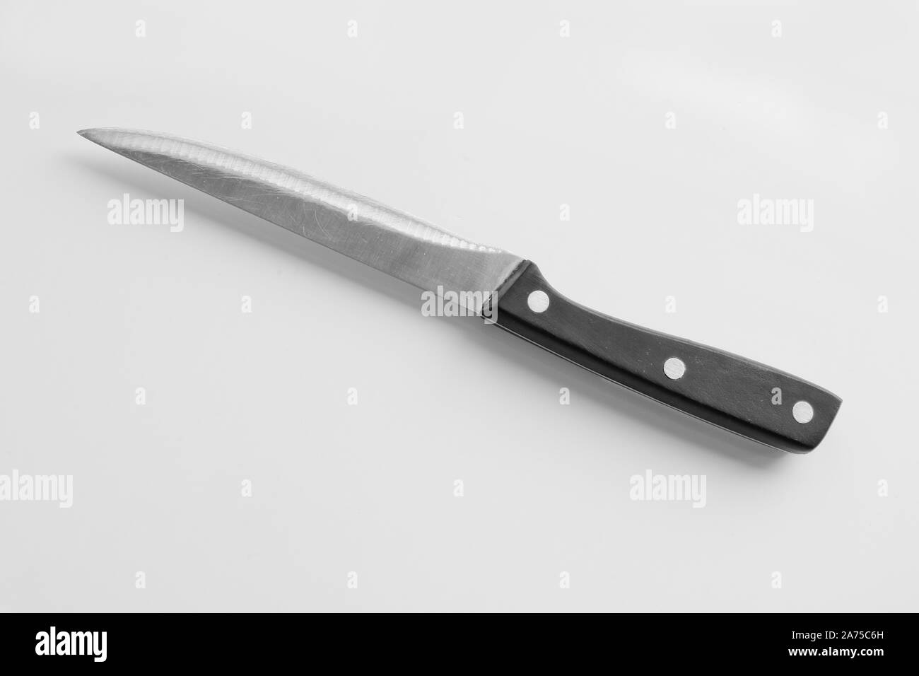 Kitchen utensils - a universal knife with a black plastic handle on a light background. Cooking tools. Stock Photo
