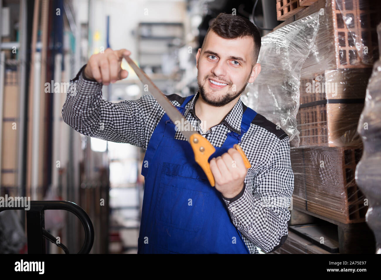 Positive construction man showing various tools at workplace Stock ...