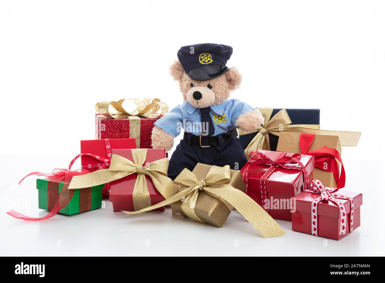Police and christmas concept. Cute teddy bear in police officer uniform and xmas gift boxes isolated against white background Stock Photo