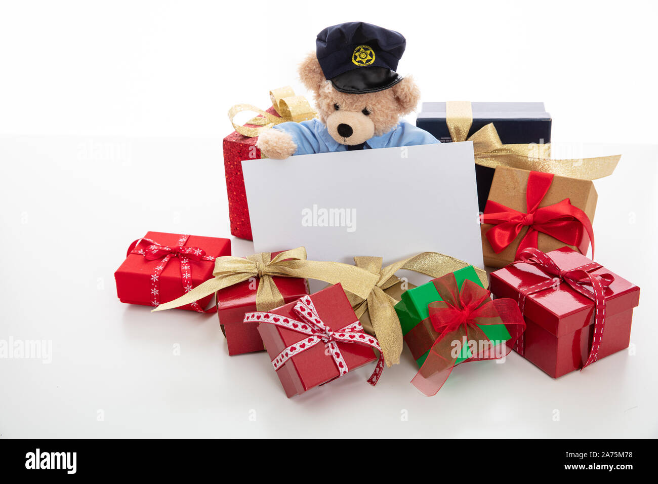Police and christmas concept. Cute teddy bear in police officer uniform and xmas gift boxes isolated against white background, copy space Stock Photo