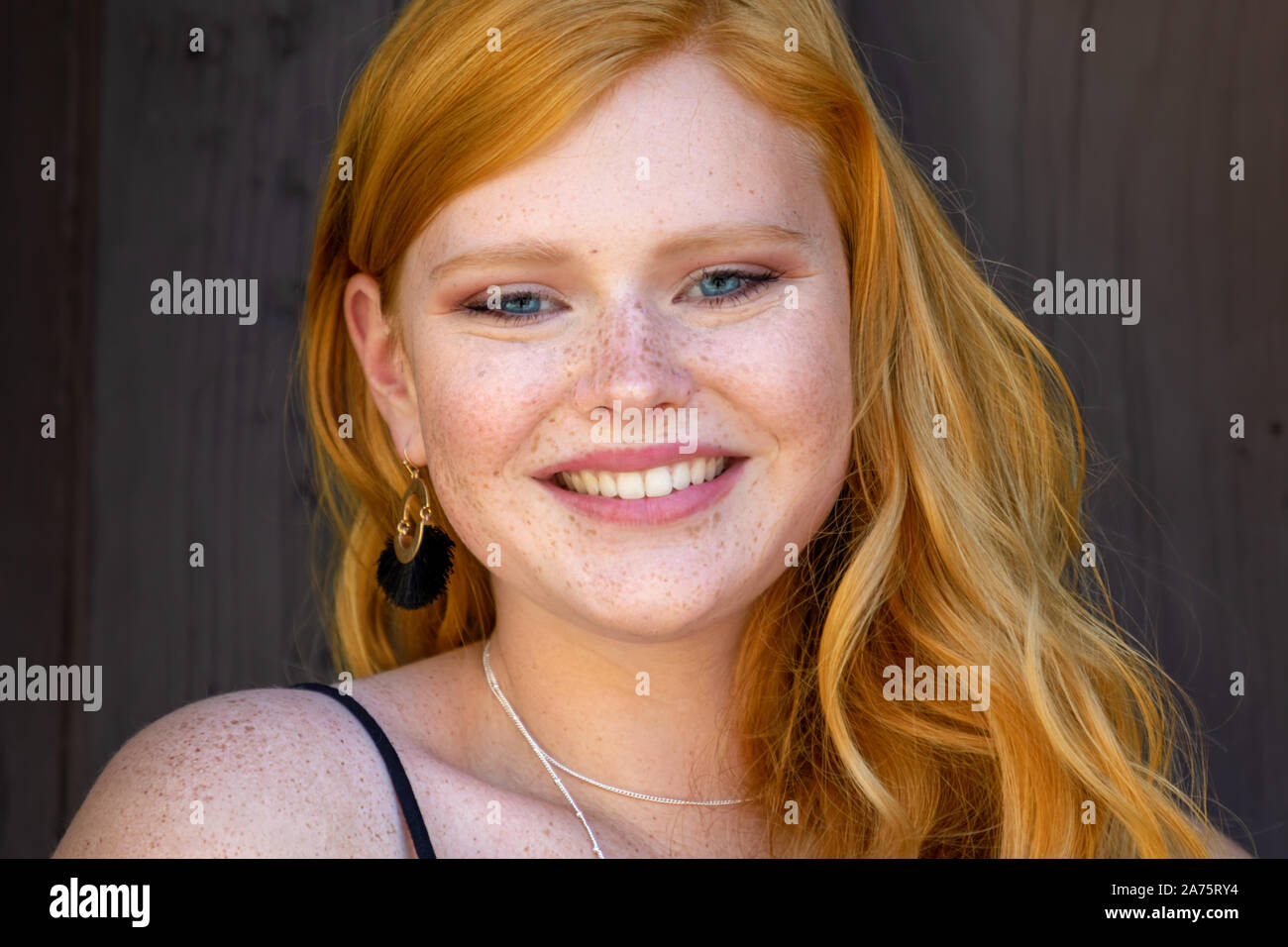 Portrait of a gorgeous smiling teenage girl with red hair and freckles Stock Photo