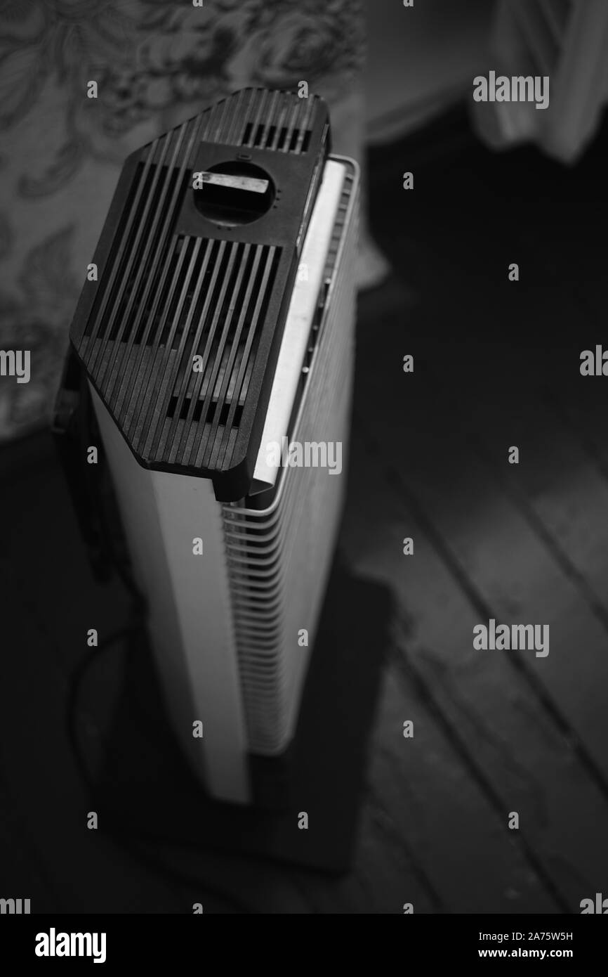 Retro electric heater Ugolek in the room, bw photo. Stock Photo