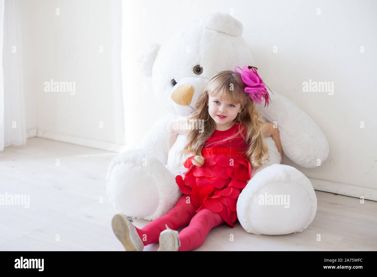 Beautiful girl holds a large soft toy polar bear Stock Photo - Alamy