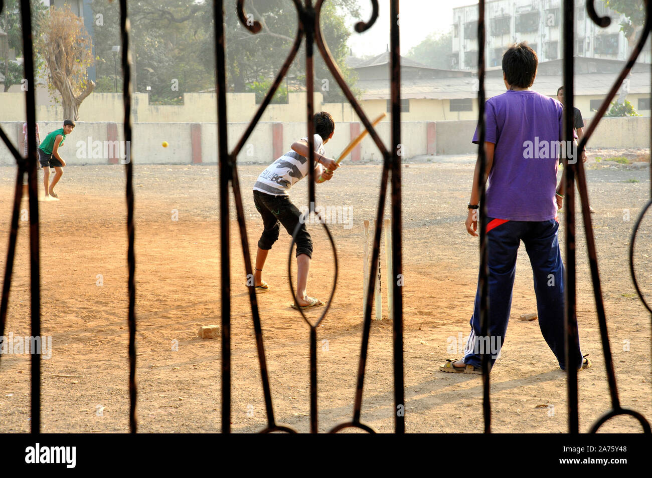 Mumbai, Maharashtra, India, Southeast Asia -  Feb..2, 2012 :  Indian's favorite game Rural Boys Playing Cricket in open ground in mumbai Stock Photo