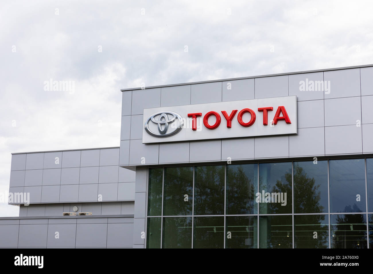 Minsk Belarus July 15 19 Toyota Logo And Signature On Gray Tiles Building With Dark Windows On Gray Cloudy Sky Background Toyota Is A Japanese Stock Photo Alamy
