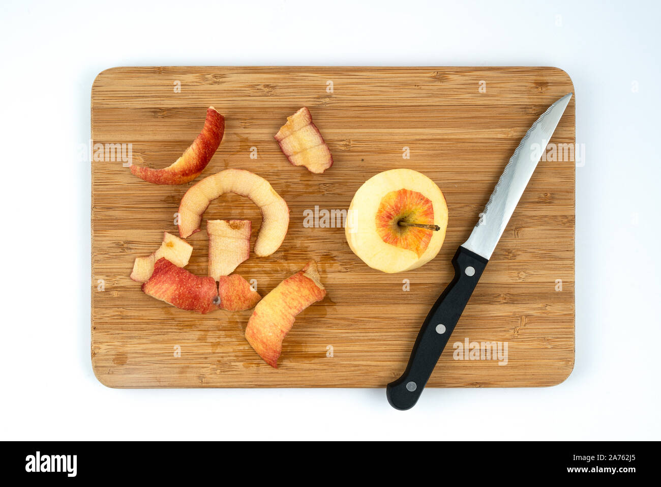 a peeled apple on a wooden board Stock Photo