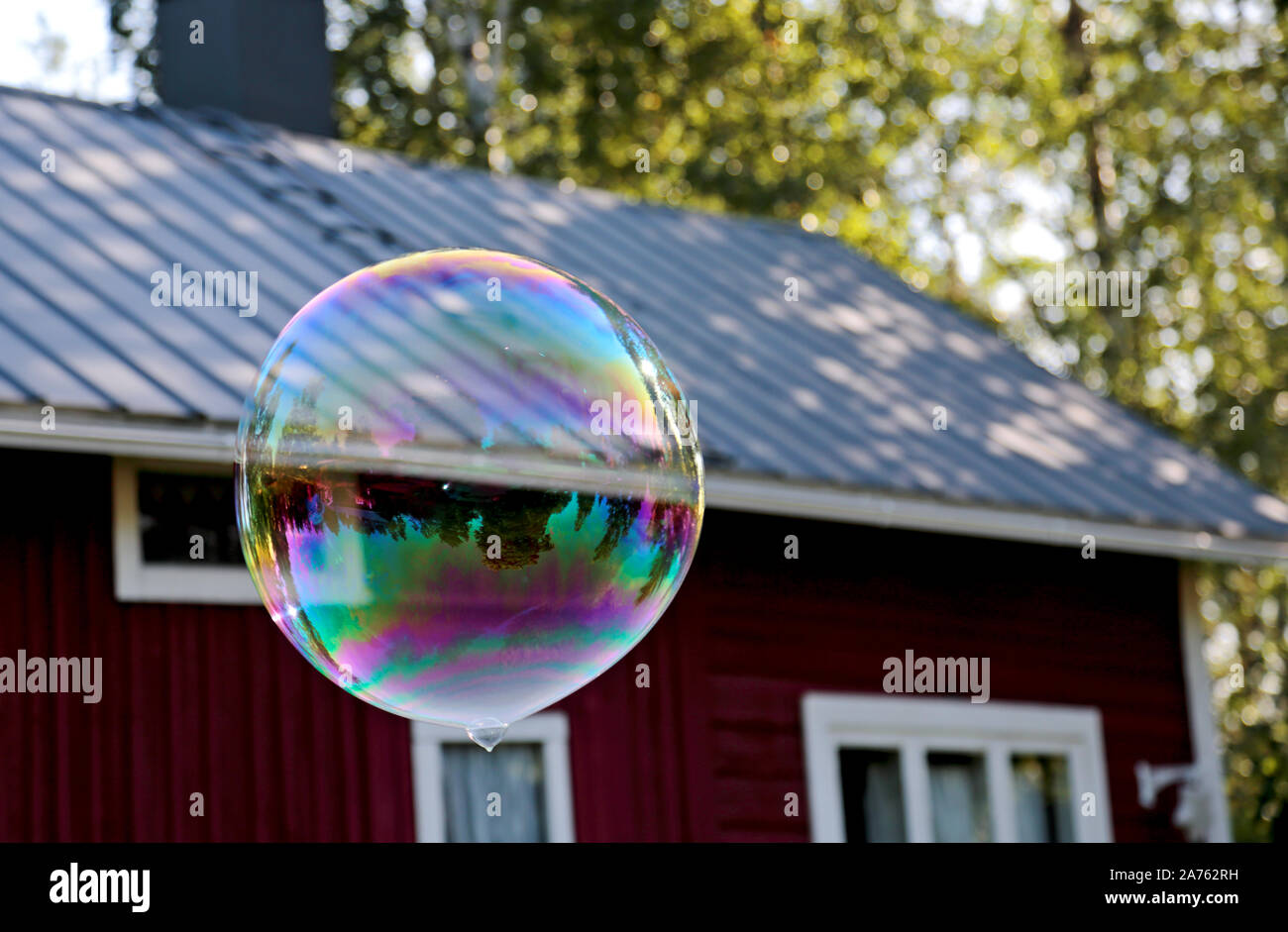 A big soap bubble in different colors flying in the air Stock Photo - Alamy
