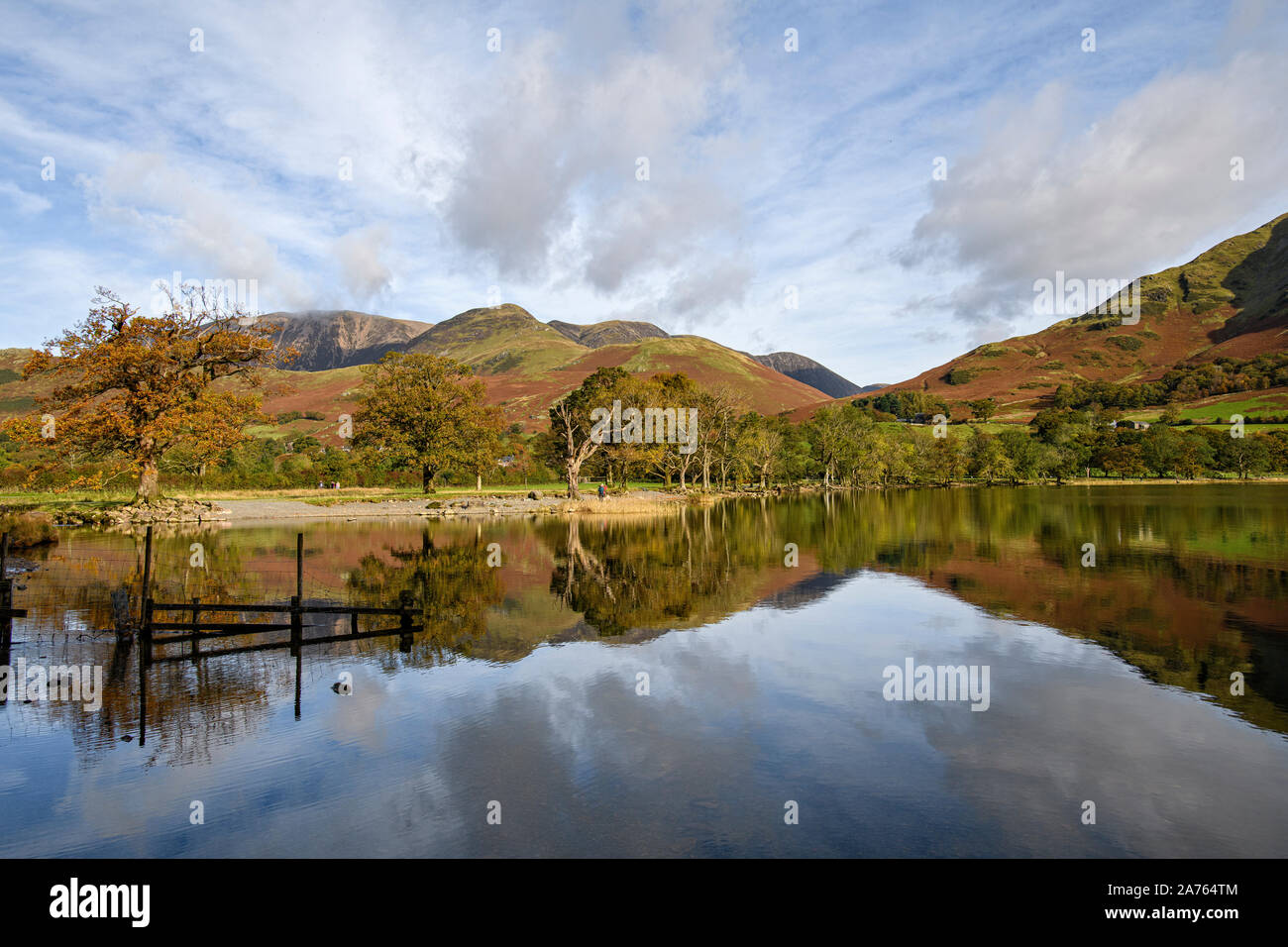 Autumn reflections of trees and fells along the Buttermere shoreline Stock Photo