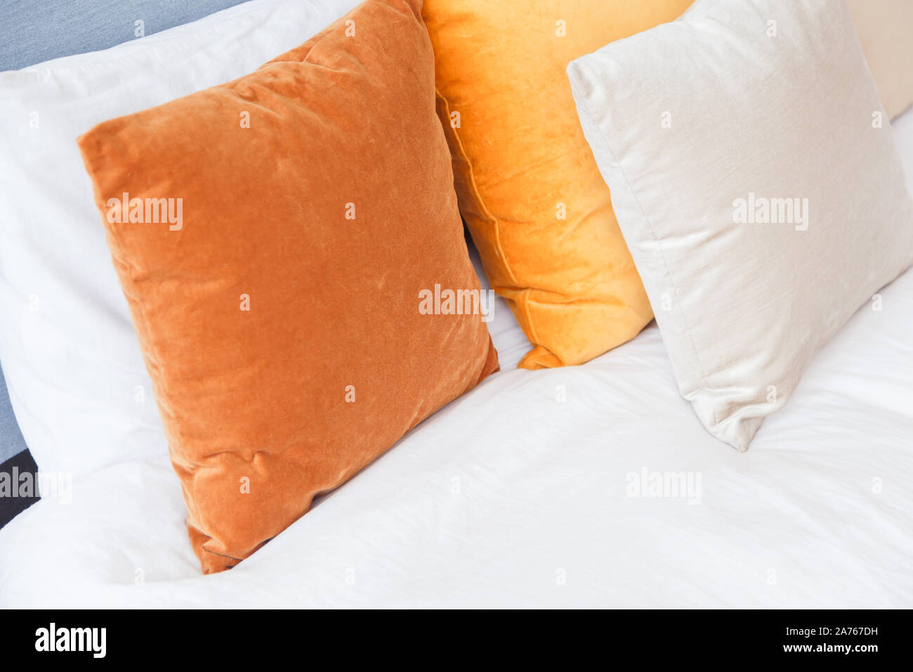 Colored velvet pillows on the bed. Elements of home comfort. Stock Photo