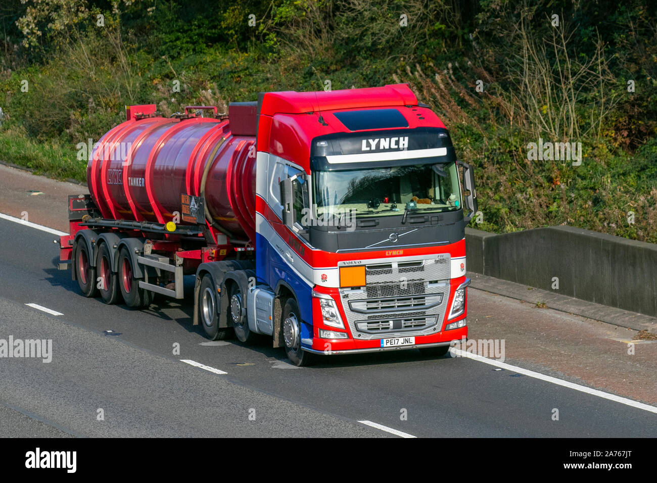 Red LYNCH Haulage tanker delivery trucks, lorry, transportation, truck, cargo, MAN Volvo FH vehicle, commercial transport, leisure industry vehicles on the M6 at Lancaster, UK Stock Photo