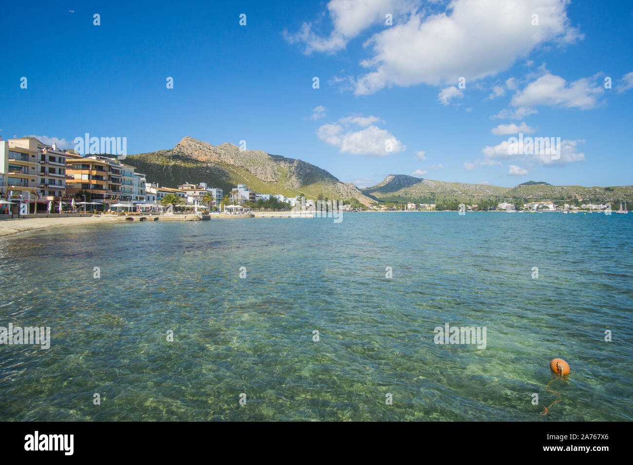 A beautiful crystal water view and Green mountains on sunny day captured from a dock at Puerto De Pollensa beach in Palma De Mallorca , Spain Stock Photo