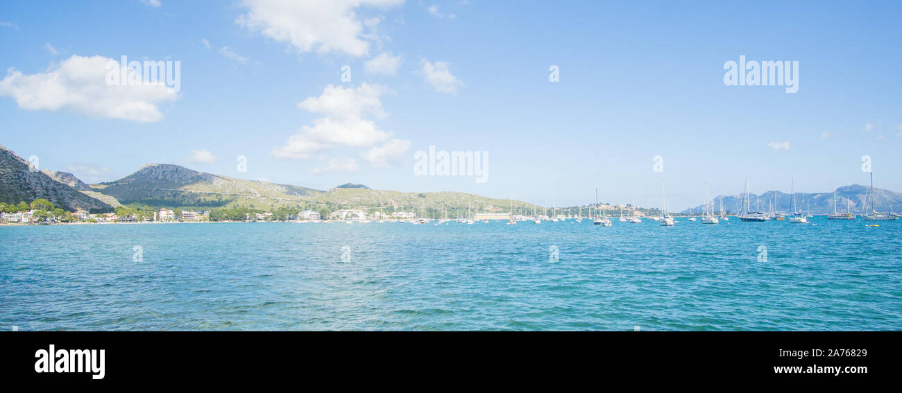 A beautiful crystal water view and Green mountains on sunny day captured from a dock at Puerto De Pollensa beach in Palma De Mallorca , Spain Stock Photo