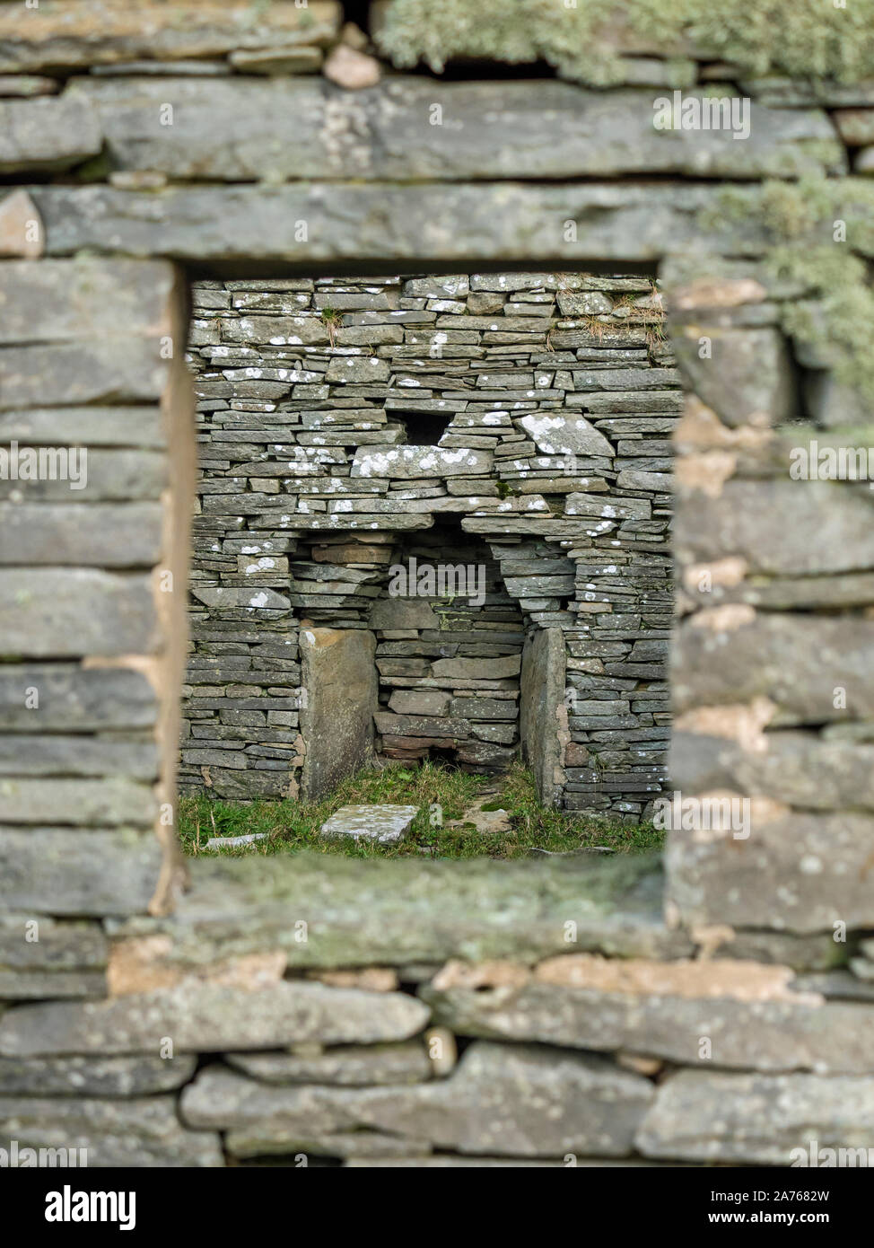 View of fireplace through window of abandoned croft house, Bressay, Shetland, Scotland Stock Photo