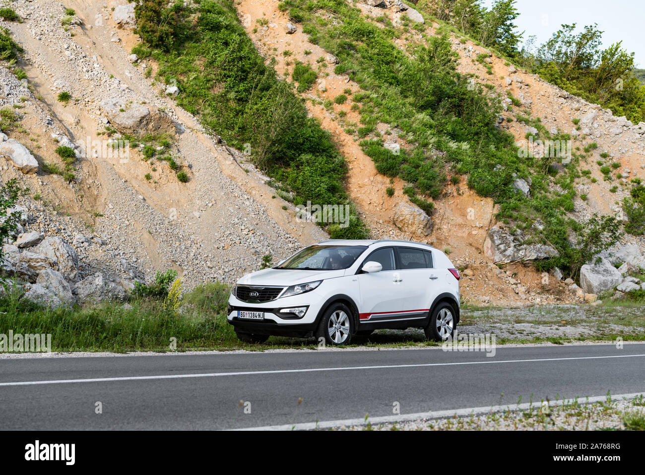 Car Kia Sportage 2.0 CRDI awd or 4x4, white color, parked on gravel, near highway, which past thru the rocky mountains Stock Photo