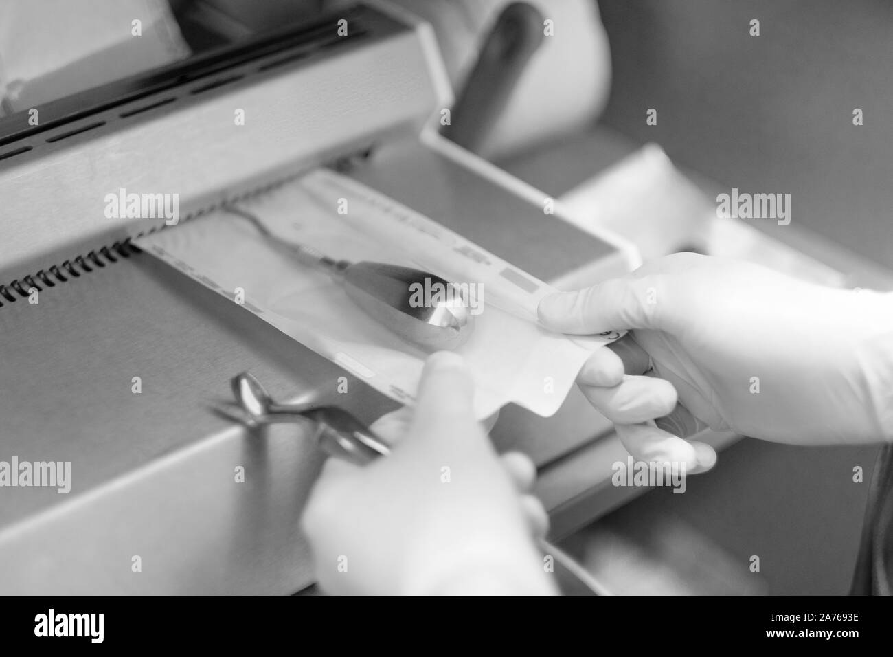 The dentist's assistant packs a dental instrument for autoclaving in a