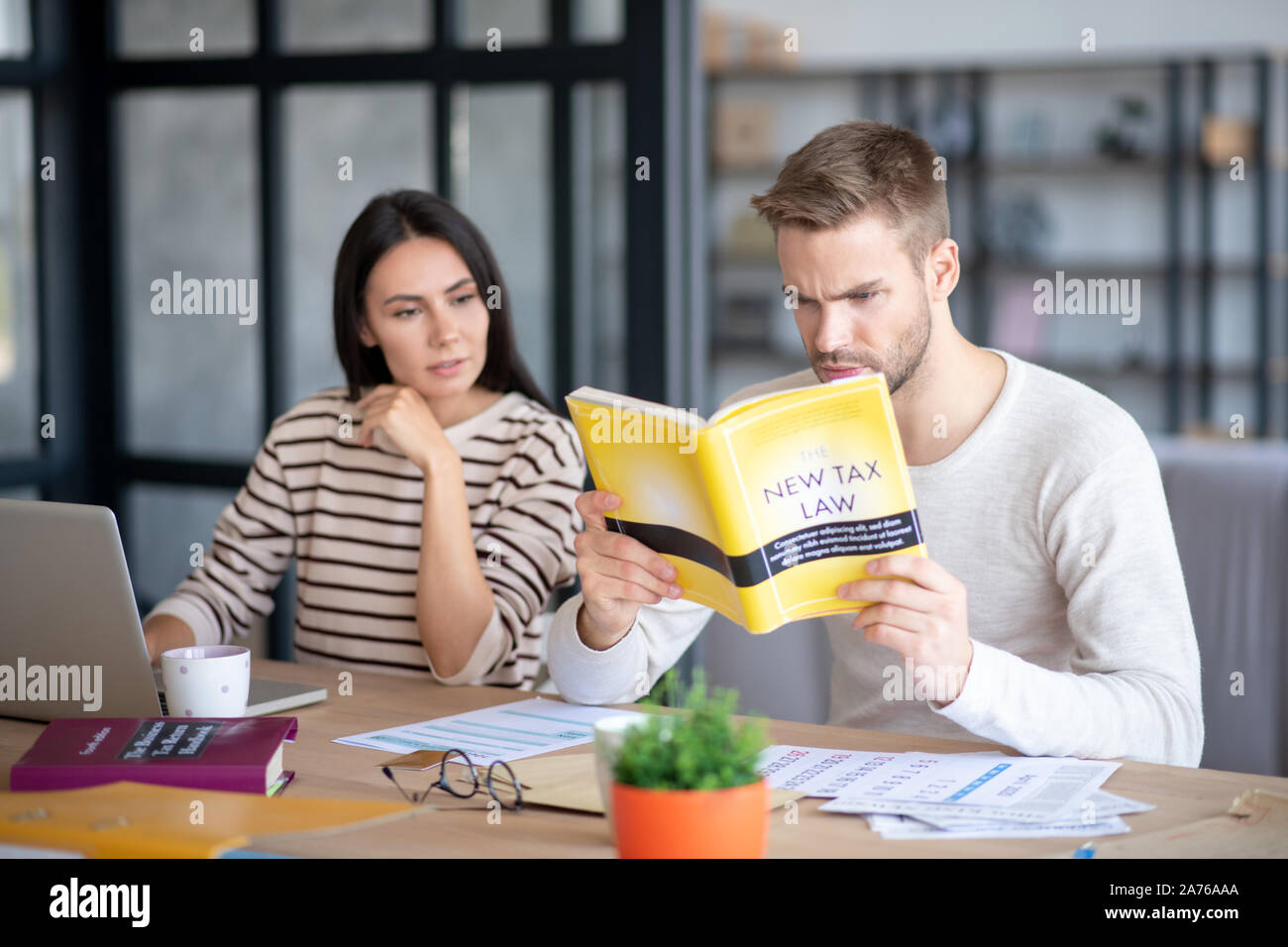 Blue-eyed husband feeling involved in studying new tax law Stock Photo