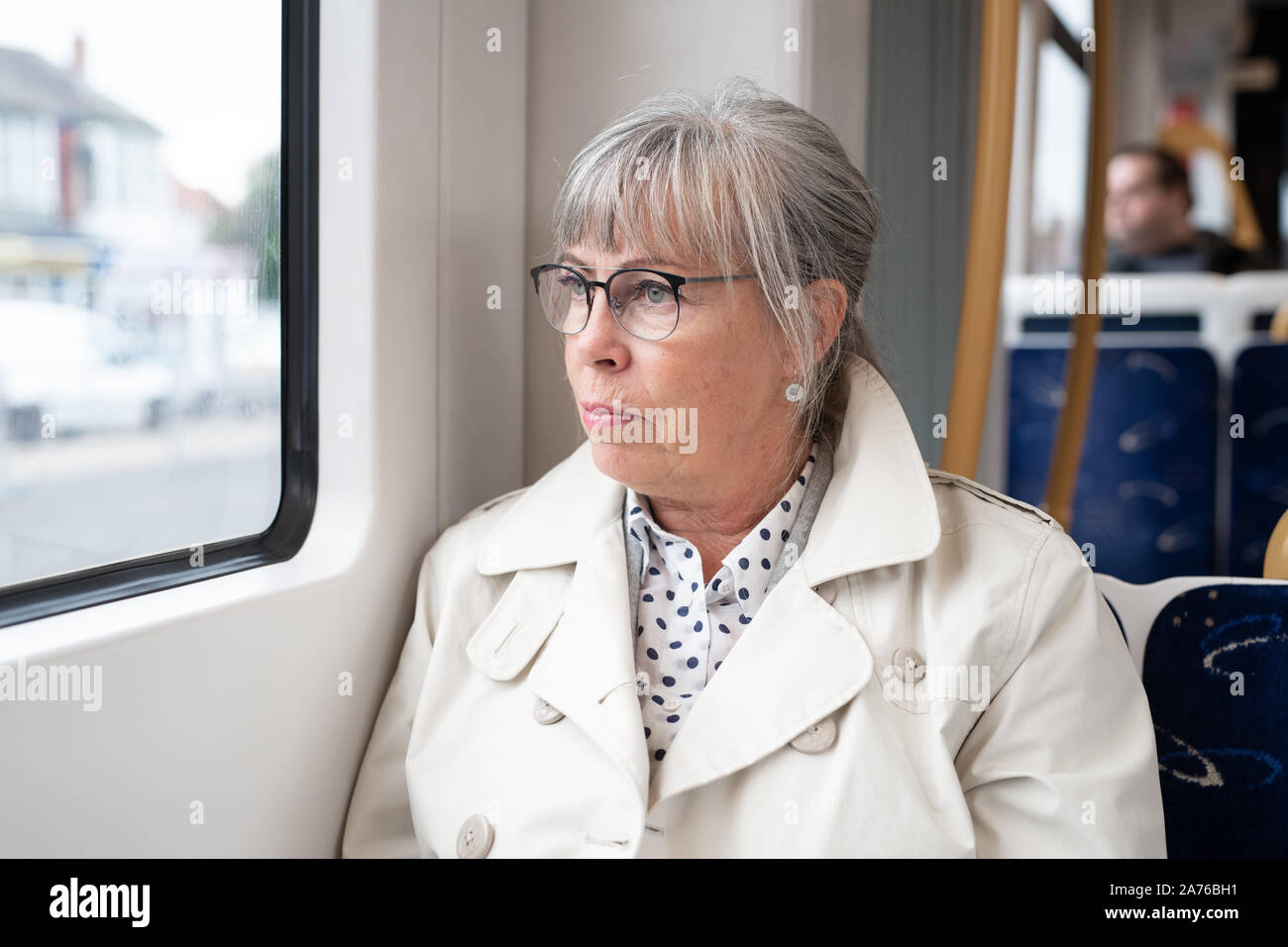 Senior woman sitting on train looking out window Stock Photo