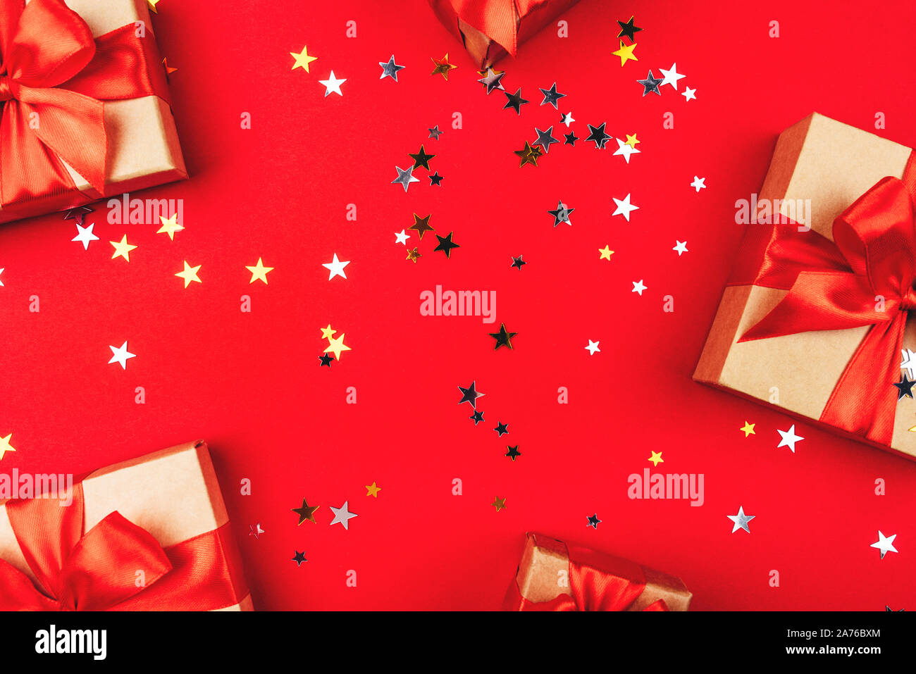 Several gift boxes with bows on a red background. Stock Photo