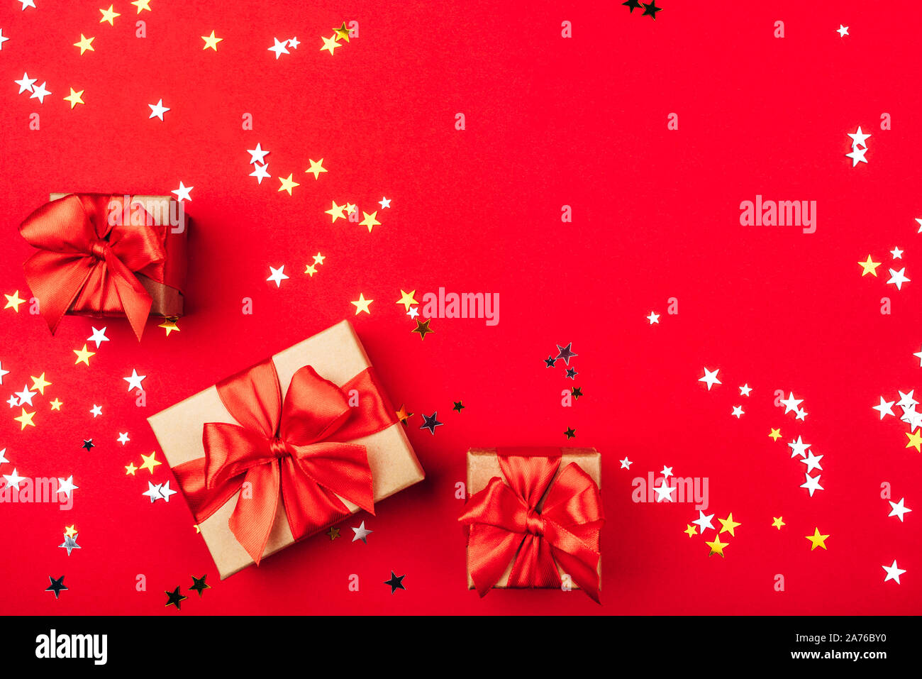 Several gift boxes with bows on a red background. Stock Photo