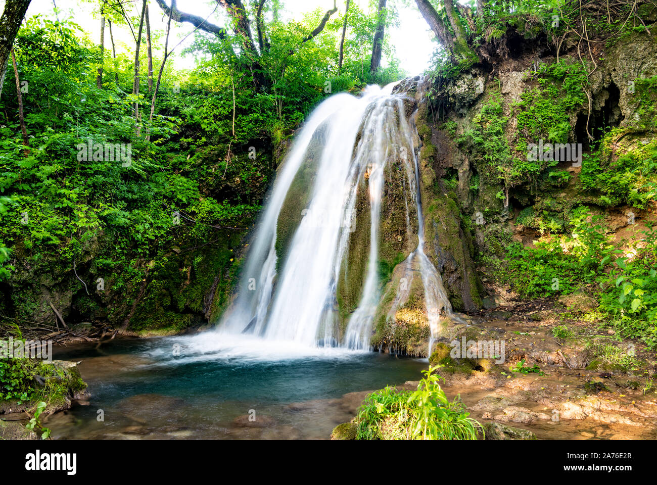 Beautiful waterfalls in village Donji Taor, Taorska vrela. Green plants and moss bloom next to water, which flows down the cascading limestone rocks. Stock Photo