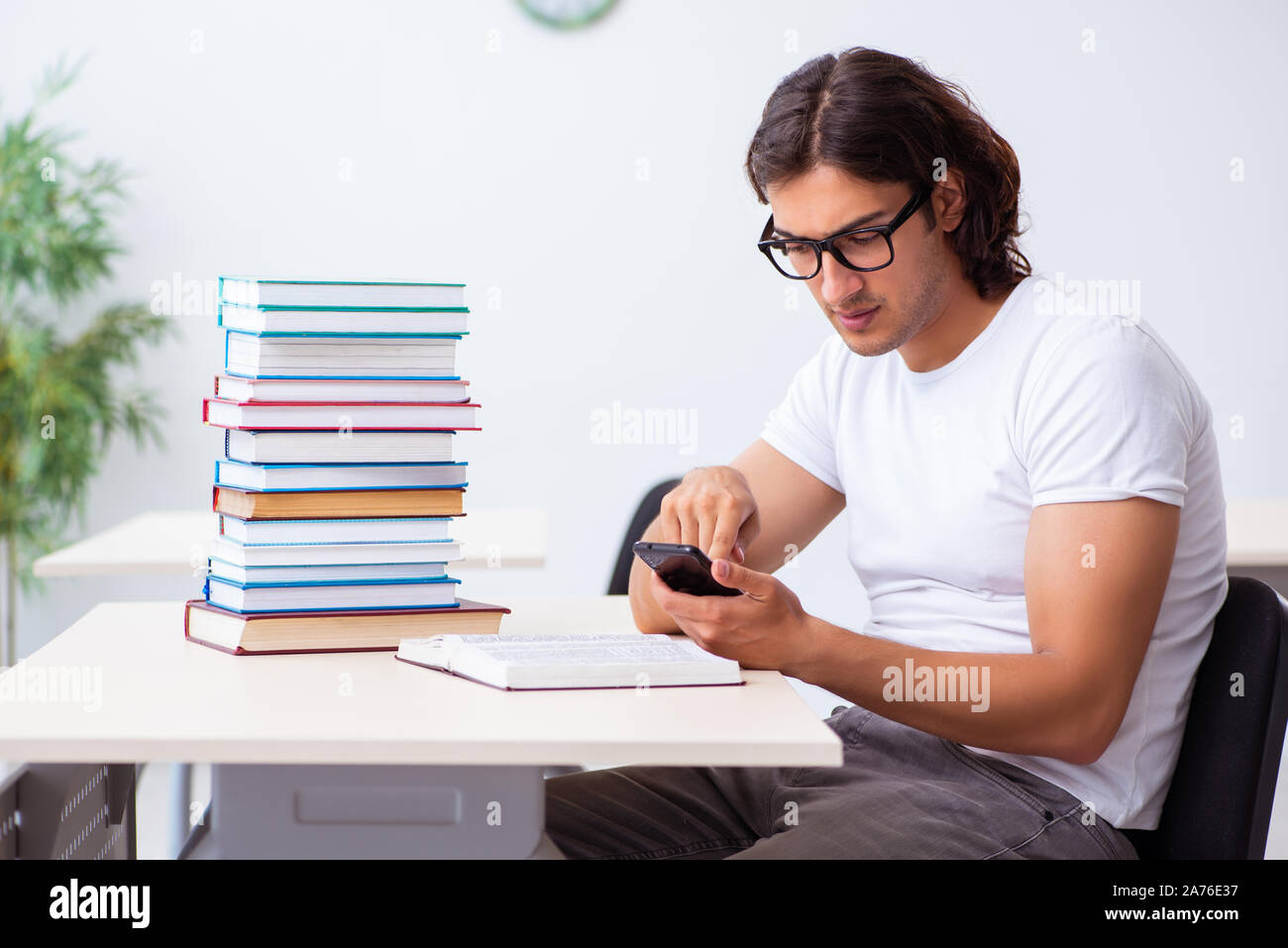 The young male student sitting in the classroom Stock Photo - Alamy