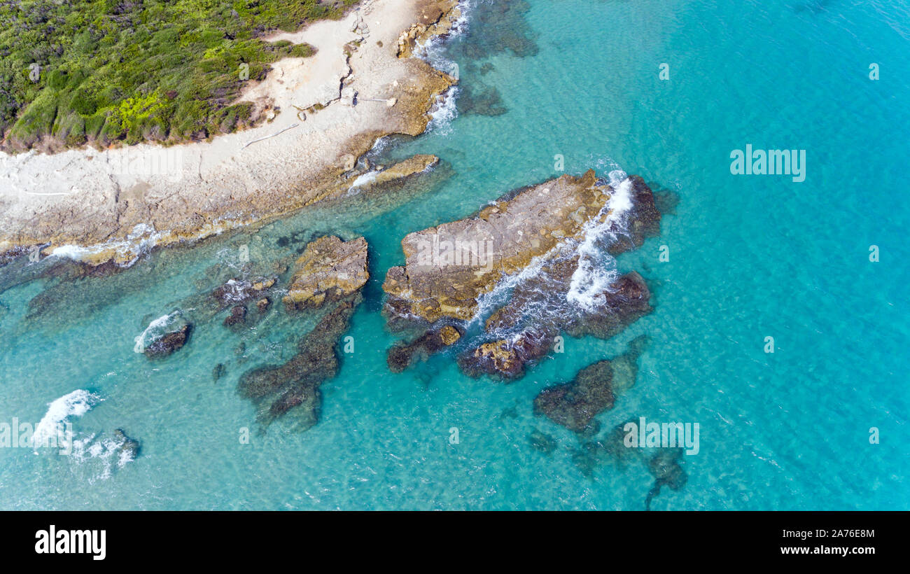 Aerial view of rock formations in blue waters of Adriatic Sea, on picturesque Puglia coast, near Baia dei Turchi, southern Italy . Stock Photo