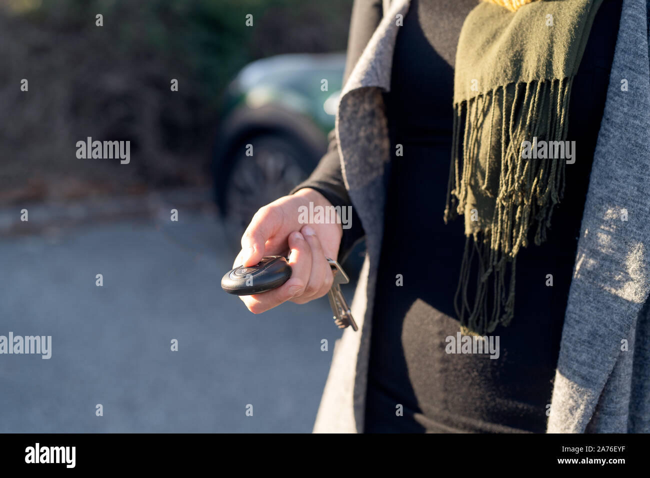 Person's hand unlocking the car with remote control Stock Photo