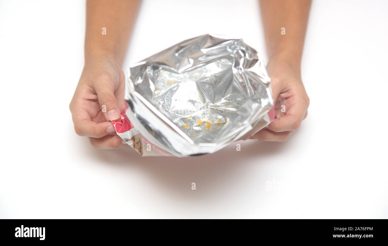 empty package from under the chips in hands Stock Photo