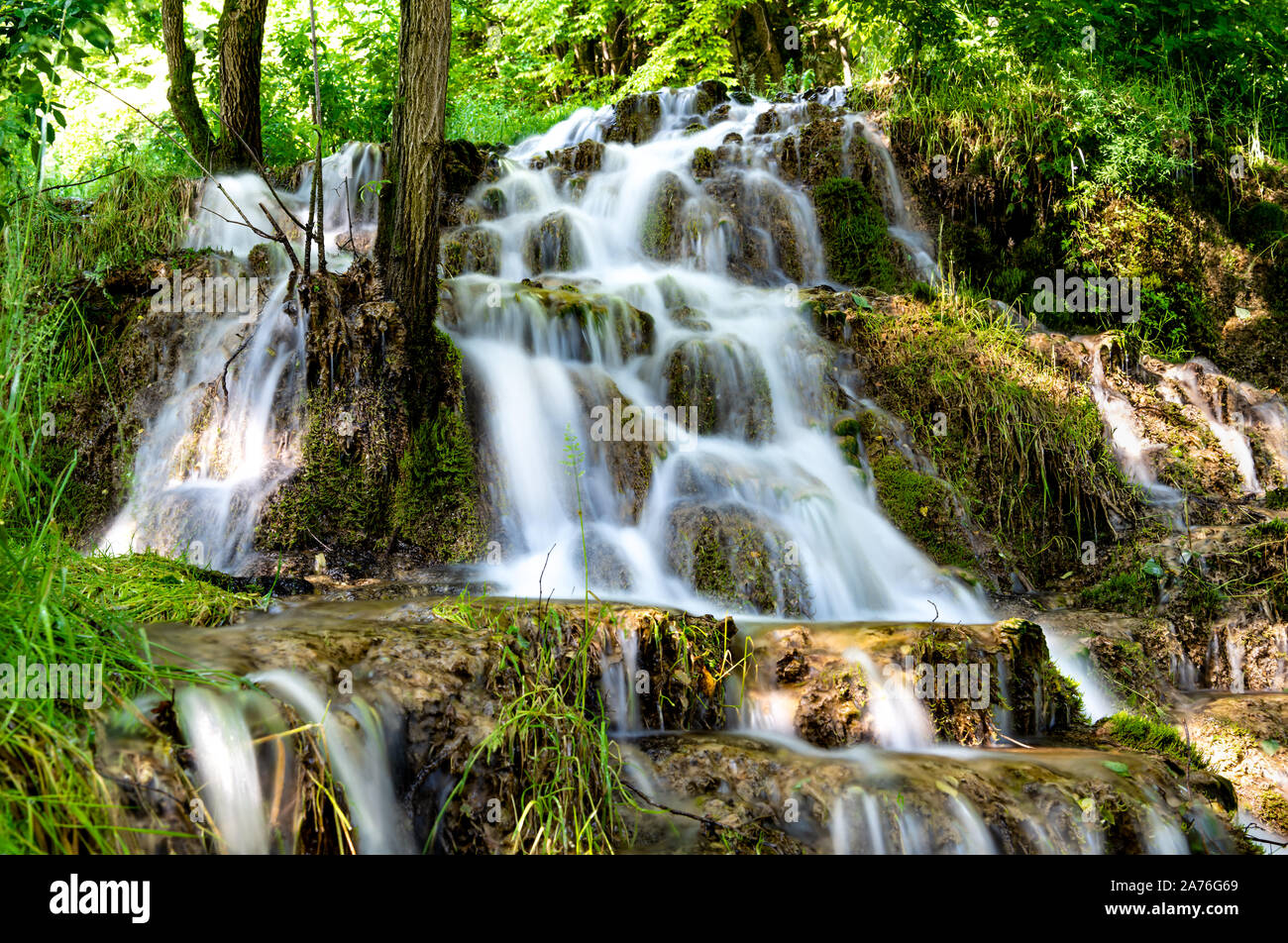 Beautiful waterfalls in village Donji Taor, near Valjevo, Serbia, Taorska vrela. Green plants and moss bloom next to water, which flows down the rocks Stock Photo