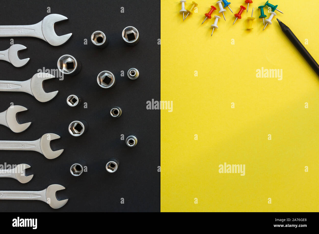 Flat Lay Composition With Different Construction Tools on Black and Yellow Background. Top View of Checklist and Working Tools, Wrench, Screwdriver Stock Photo