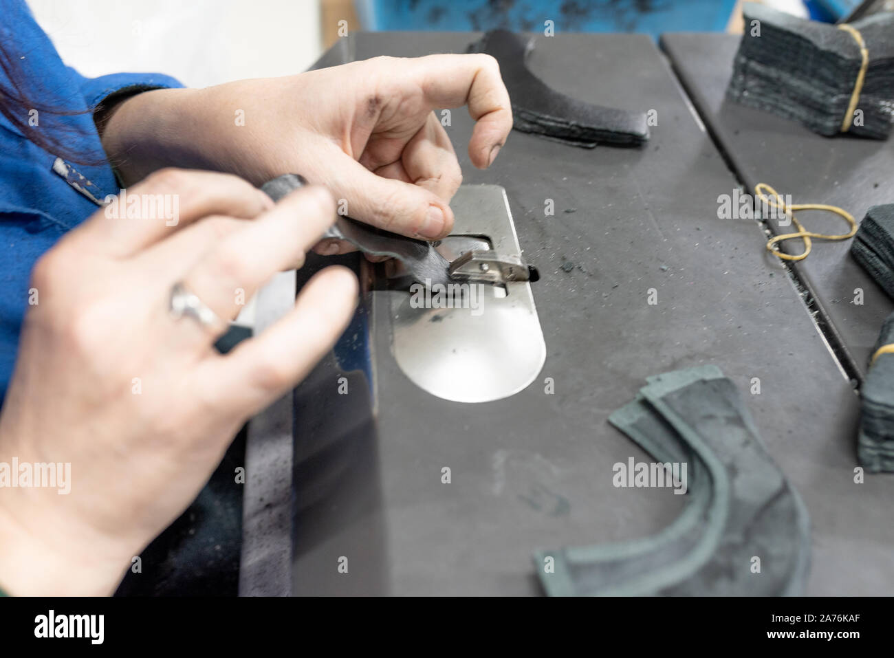 Lowering the edges of parts. Shoe production. Stock Photo