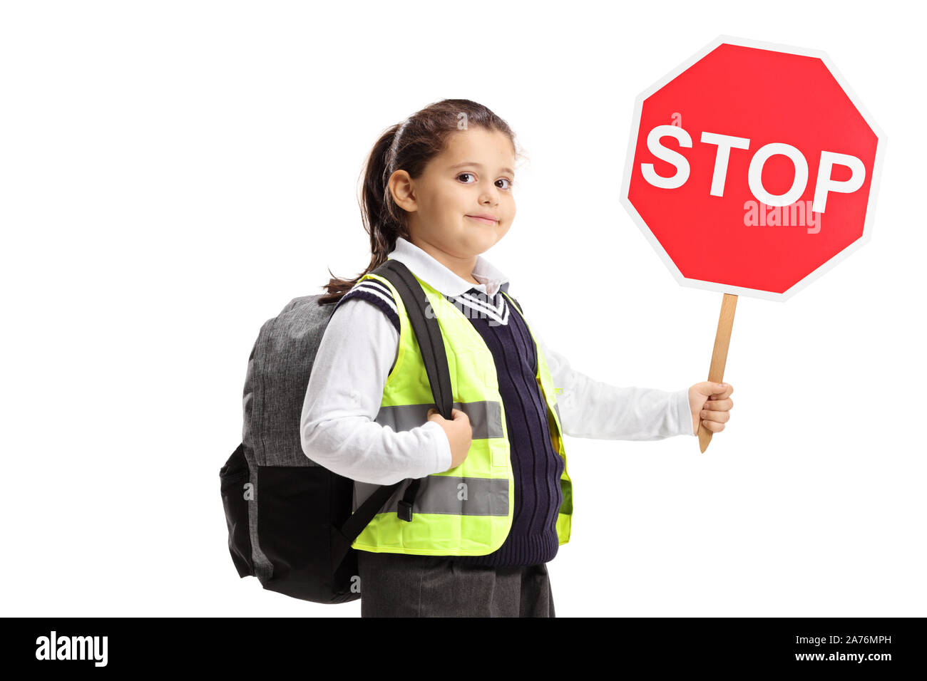 Schoolgirl with a stop sign and wearing a safety vest against white background Stock Photo