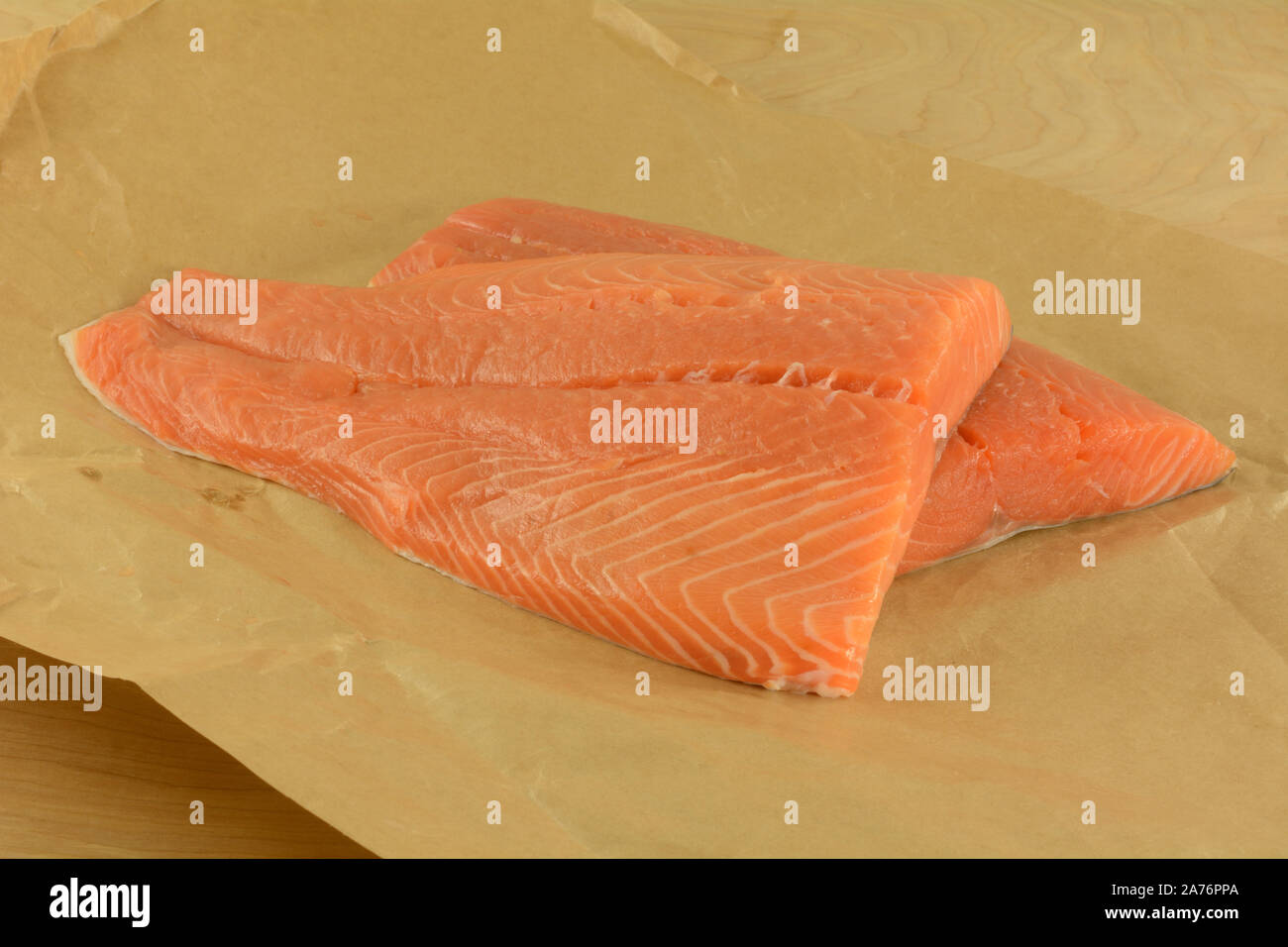 Two fresh raw salmon fish fillets on brown on opened brown butcher paper Stock Photo