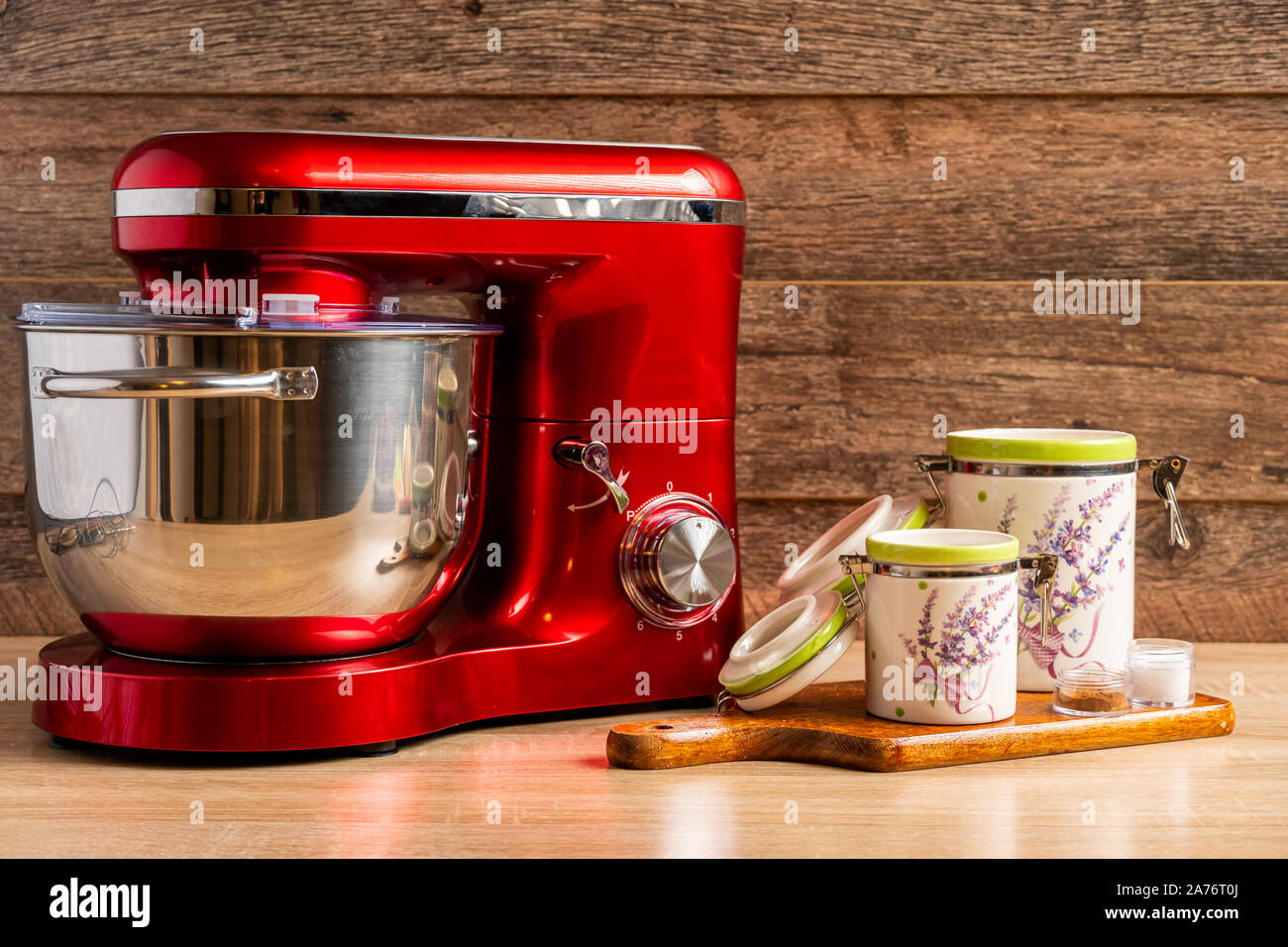 Locked stand mixer and two container jars for flour and sugar on a chopping board Stock Photo