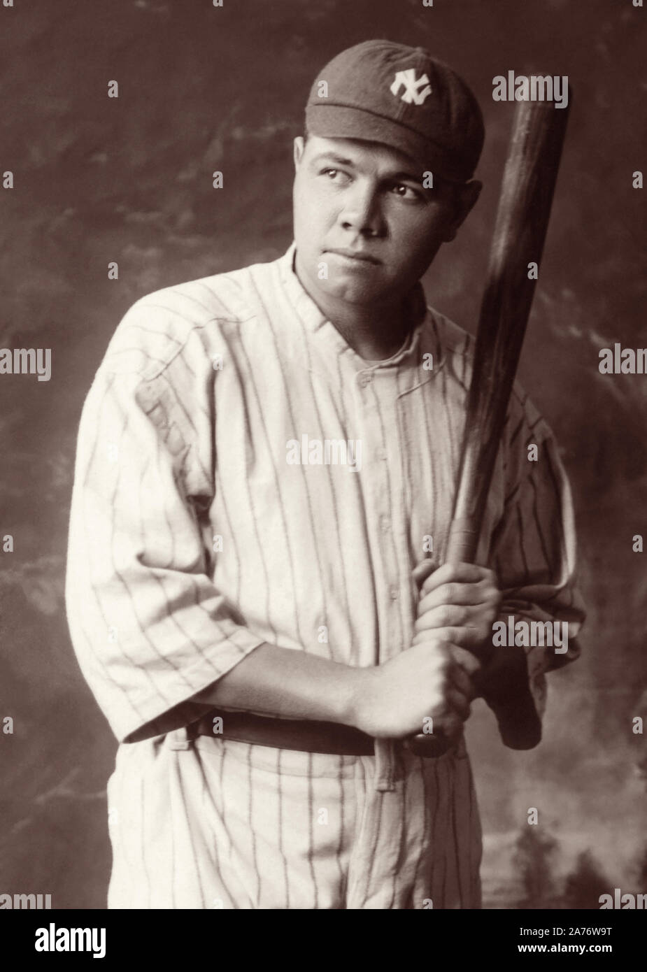 Baseball legend Babe Ruth (1895-1948) holding a baseball bat in a studio portrait, c1920. Stock Photo