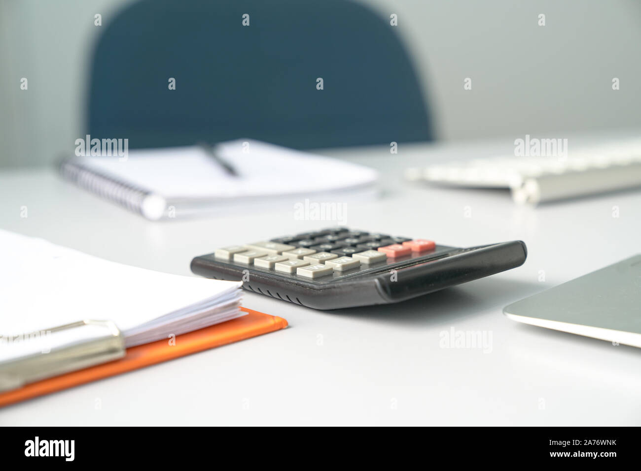 View of an Accountant's office table, focus on calculator. Empty chair